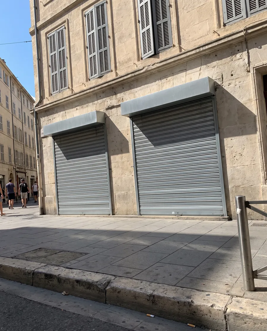 Deux rideaux métalliques pleins baissés devant une bijouterie marseillaise